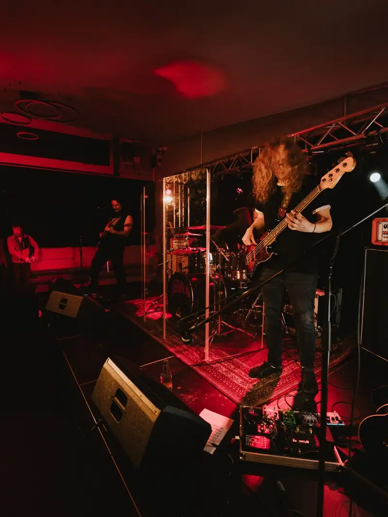 Band auf der Bühne des KULT61 im roten Bühnenlicht